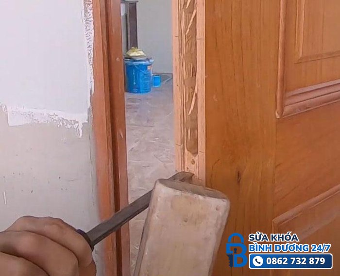 thợ dùng đục khoét lỗ lắp ổ khóa tay gạt trên cửa gỗ